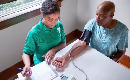 A Y staff person takes a member's blood pressure