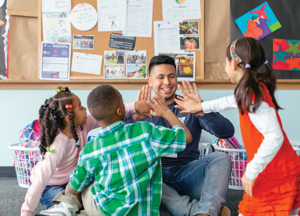 Y After School staff high five elementary school students